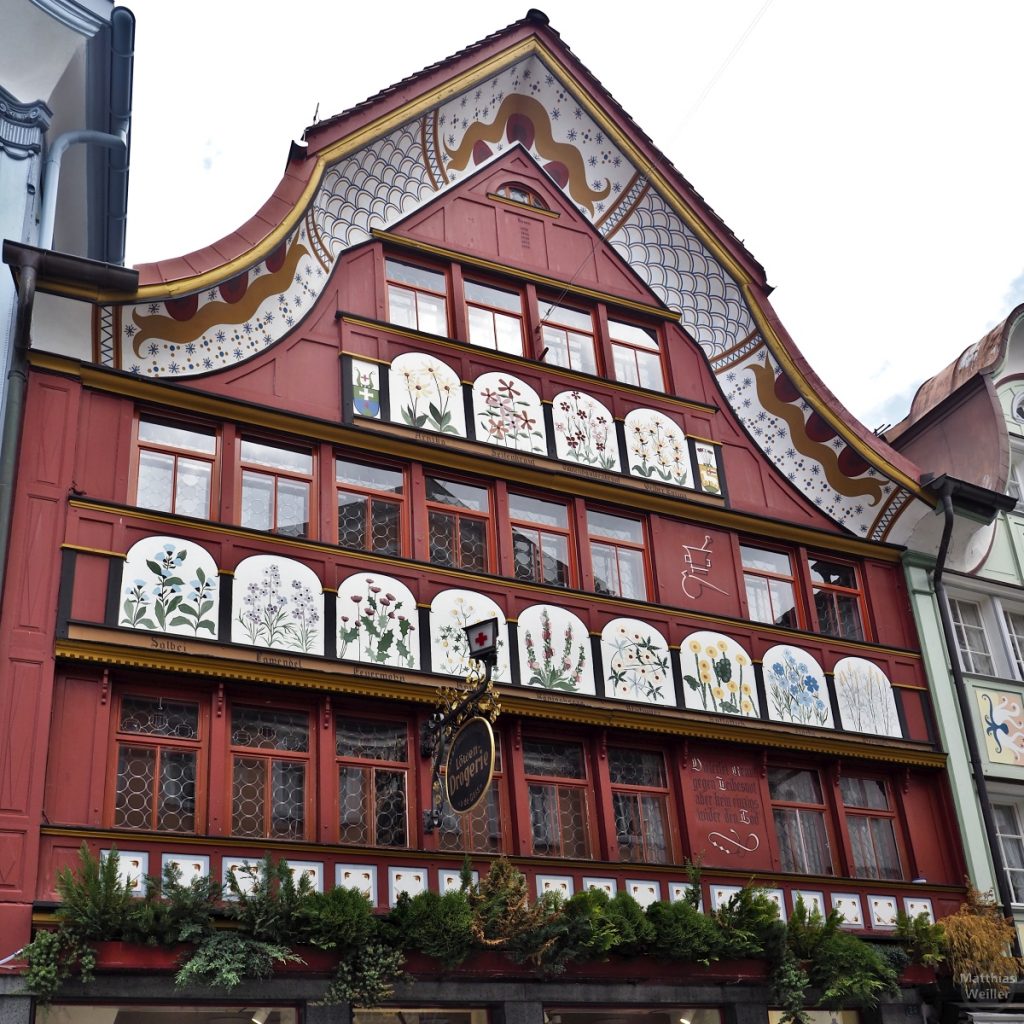 Kräuterbilder auf der bunten Fassade der Apotheke in Appenzell