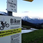 Passschild "Vorder Höhie 1536 m" und "Biker sind auch Naturfreunde", Bergkette Glarner Alpen im Hintergrund
