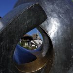 Lochblick durch Skulptur auf hsitorische Gebäude in Greifensee und Radler