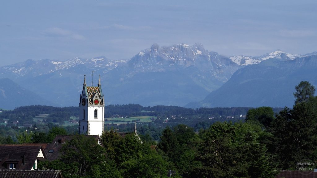Blick über bunte Kirchturmkuppel von Maur auf Alpenkette