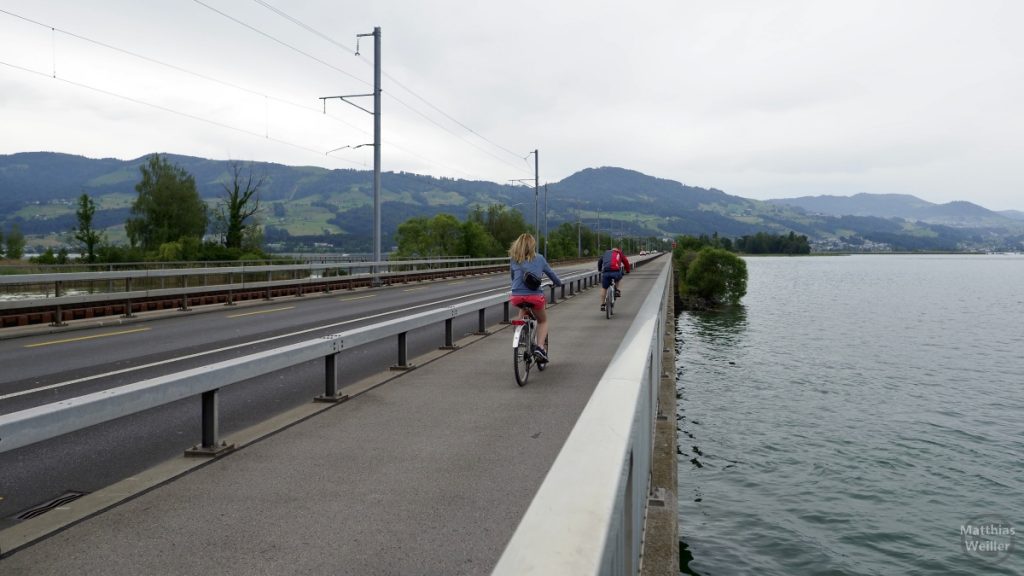 Seedamm Zürichsee mit Radlerin und Radler auf Radweg