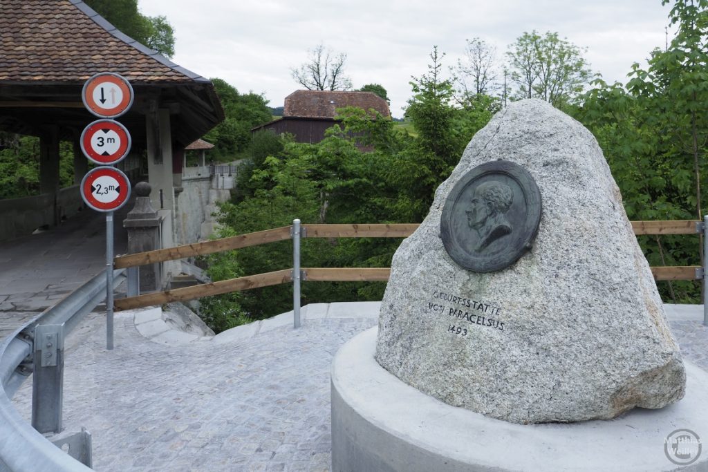 Paracelsus-Denkmalstein an seiner Geburtstätte, im Hintergrund die Teufelsbrücke