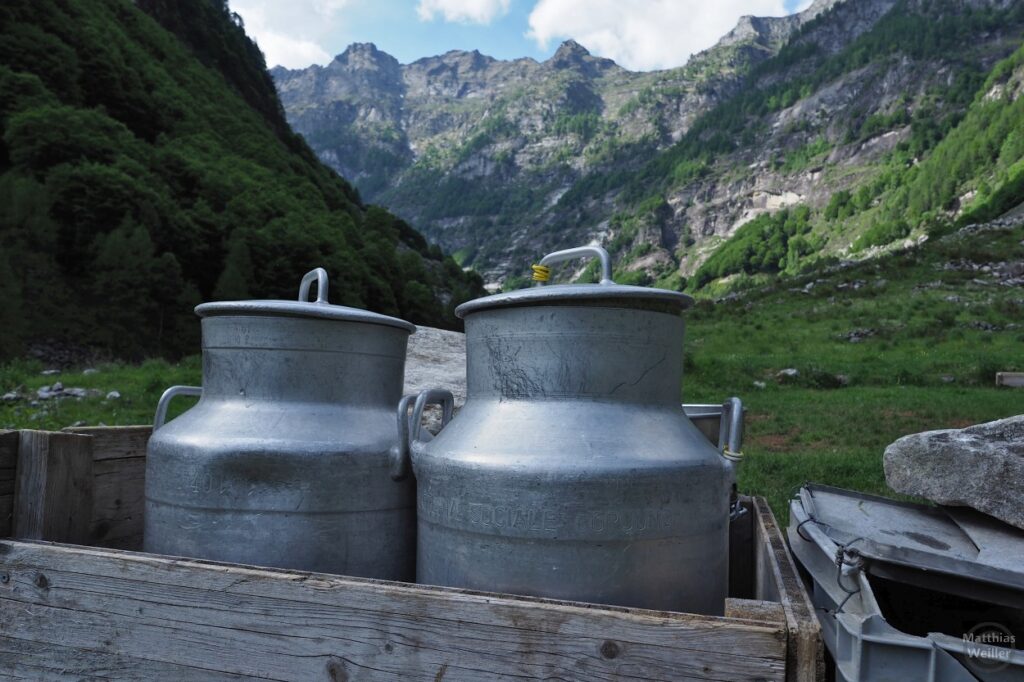 2 Milchkannen vor Bergkulisse in Secada