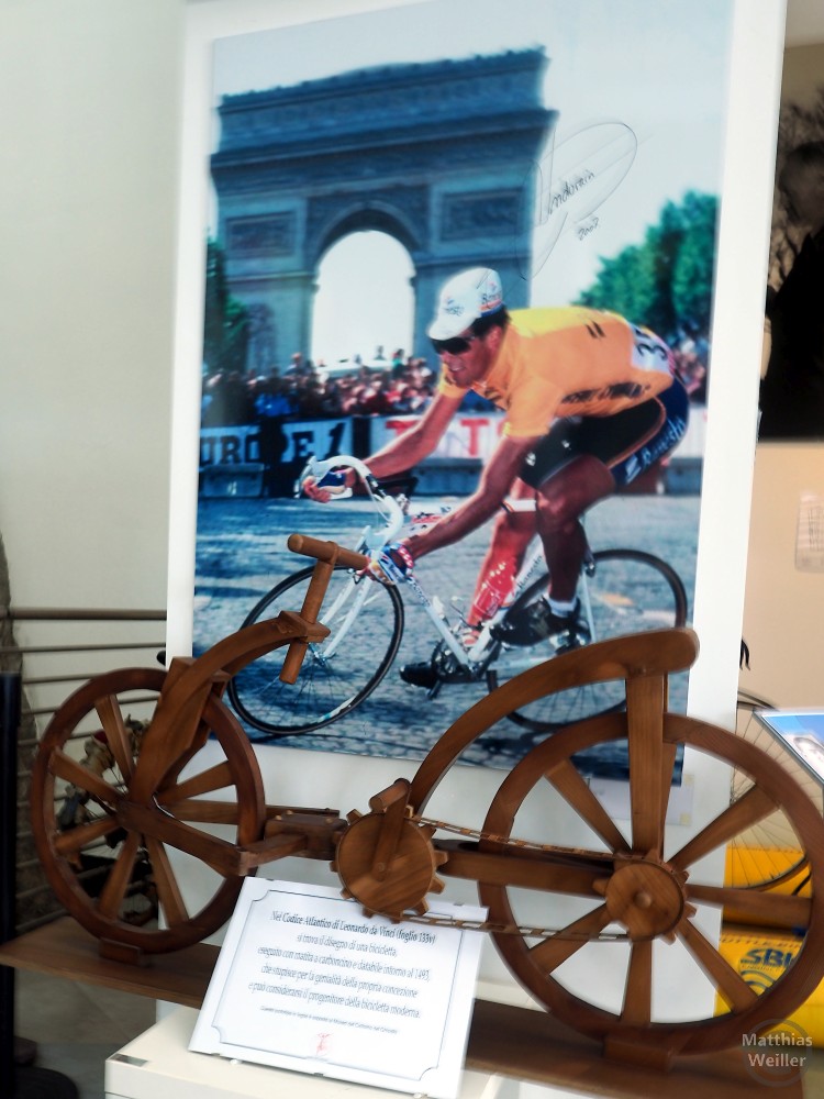 Museo del ciclismo Madonna del Ghisallo: Holzrad vor Bild mit Miguel Indurain am Arc de Triomphe