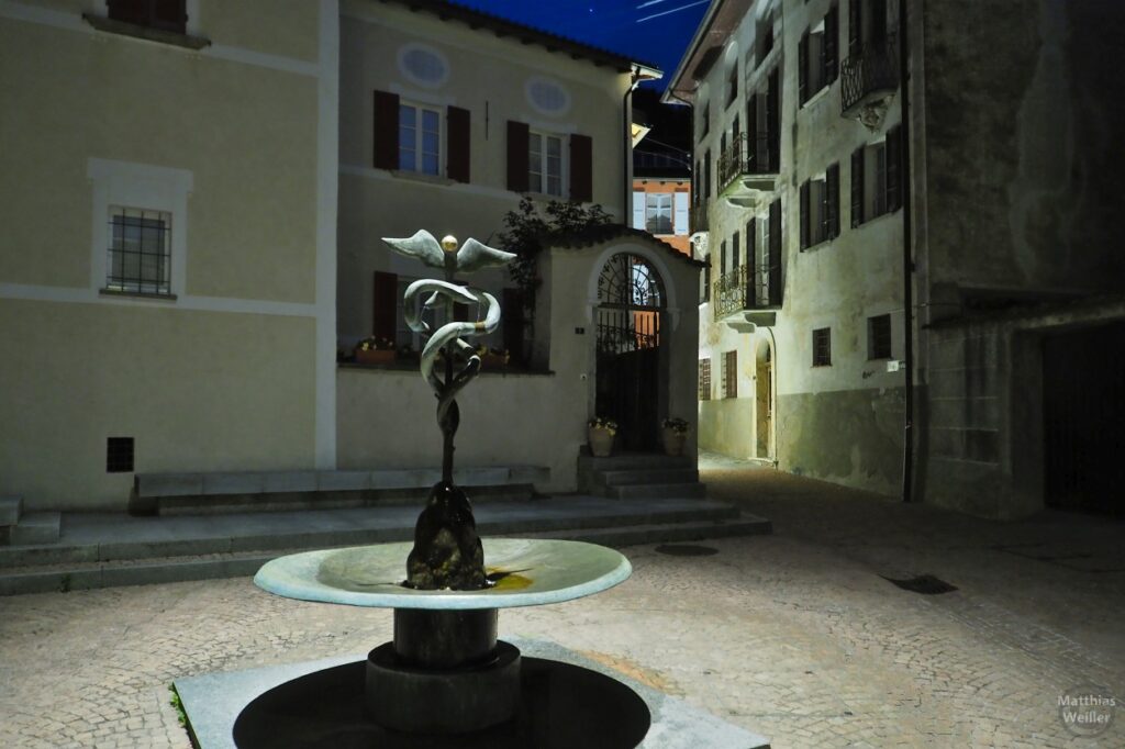 Nachtstunde in Carona, Platz mit Brunnen