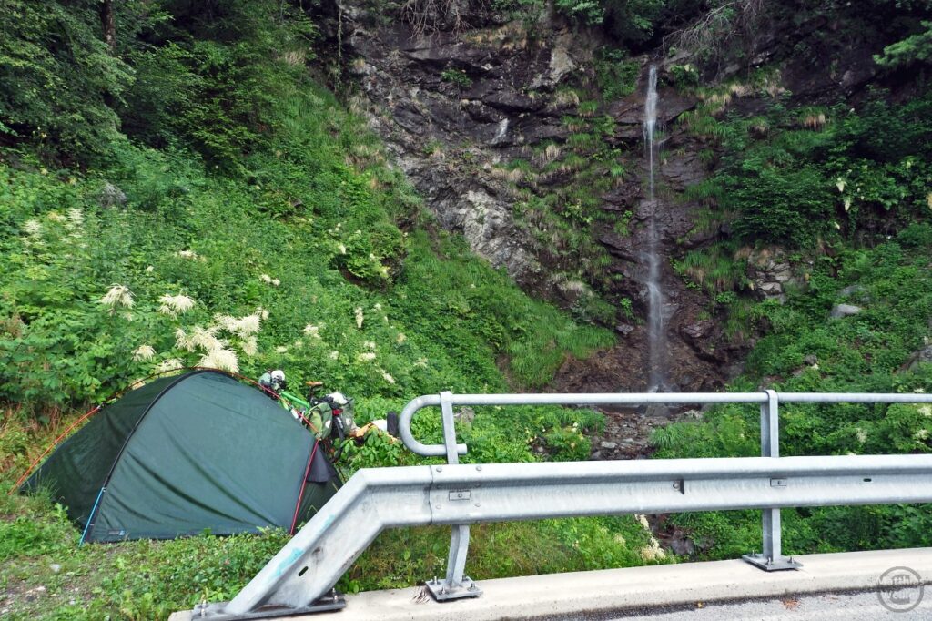 Zelt zwischen Leitplanke und Wasserfall