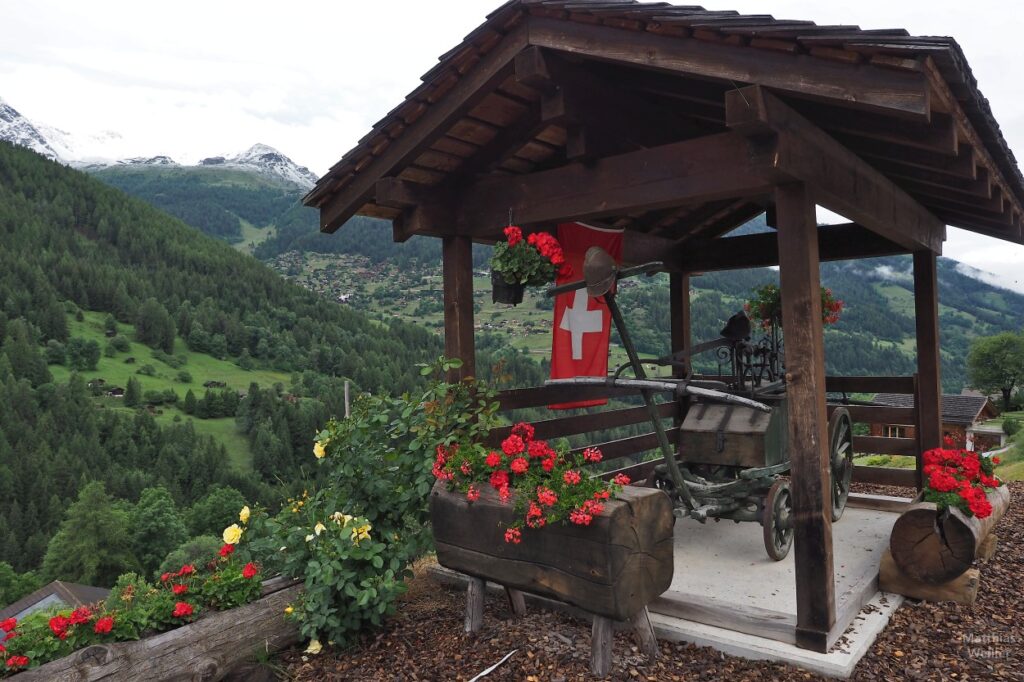 historischer Löschwagen unter offenem Holzdach mit eranien und Schweizer Flagge