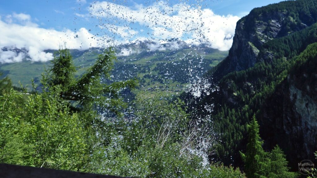 spritzendes Wasser vor Blick auf Bergkette