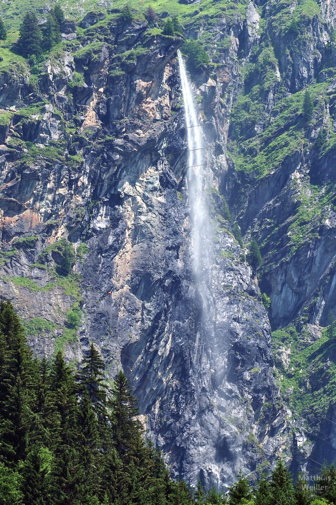schmaler Wasserfallstrahl, über Fels zerstäubend