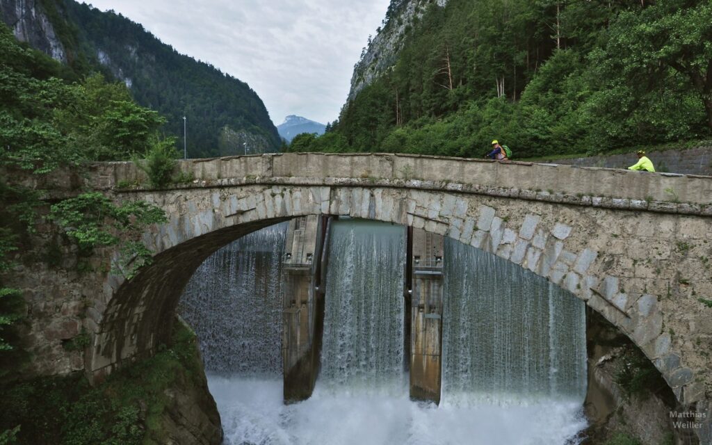 Bogenbrücke mit Stauwehrwasserfall der Simme, 2 Radler
