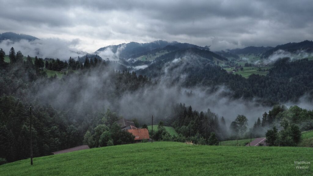 tief hängende Regenwolken über dem hügeligen Mittelland