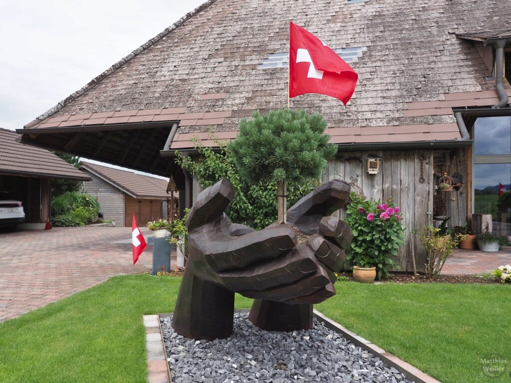 überdimensionierte Holzhand mit Schweizer Flagge