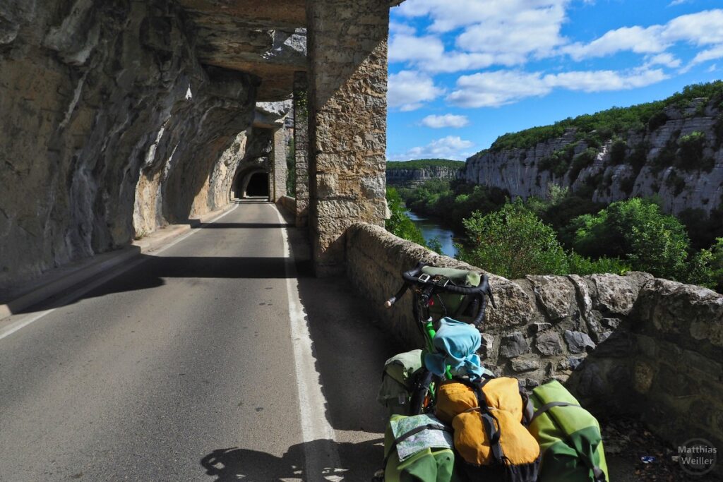 Halboffene Felsgalerie an der Ardèche-Schlucht bei Ruoms, mit Reiserad
