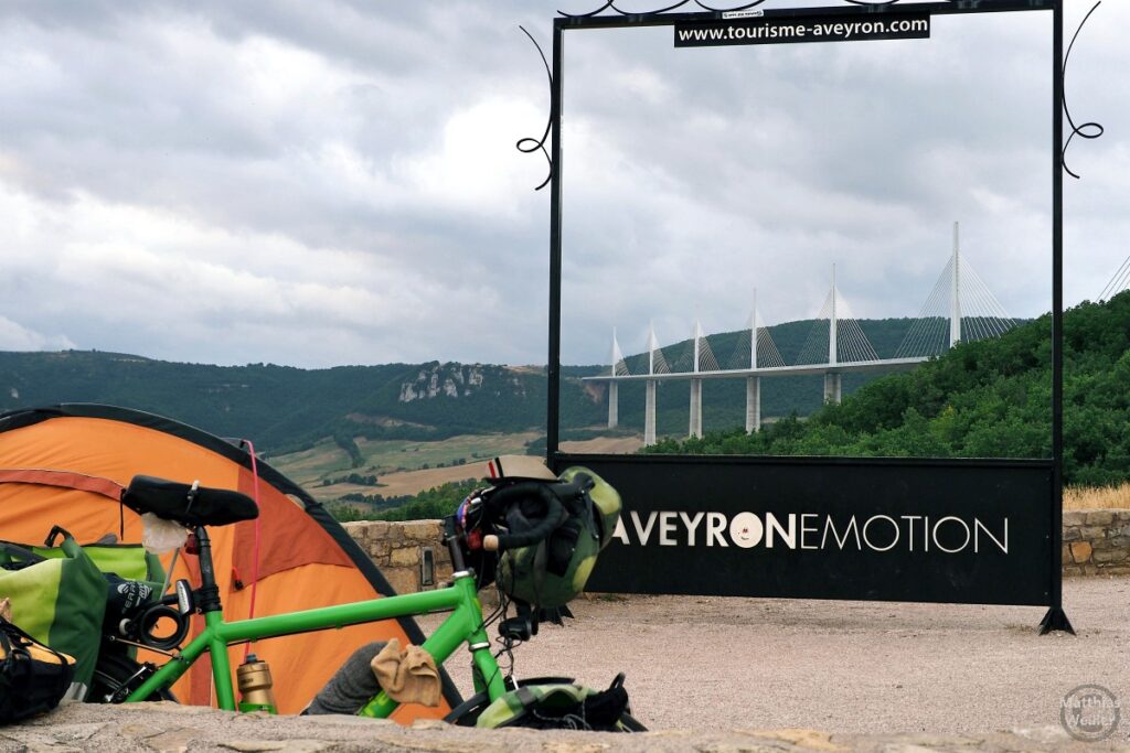Sichtfensterkosntrukt "Aveyronemotion" auf die Autobahnbrücke von Millau, mit Reisrad, Zelt im Vordergrund