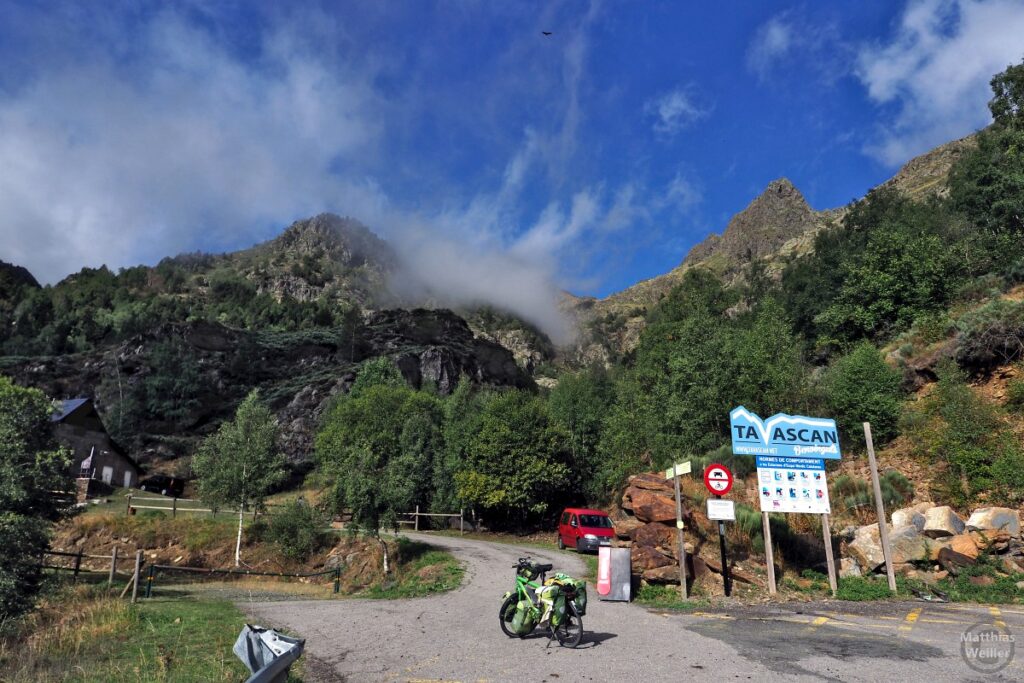 Bergtalschluss Pleta del Prat (Tavascan) mit Reiserad und sich auflösenden Wolken, Schild, Auto und Refugi