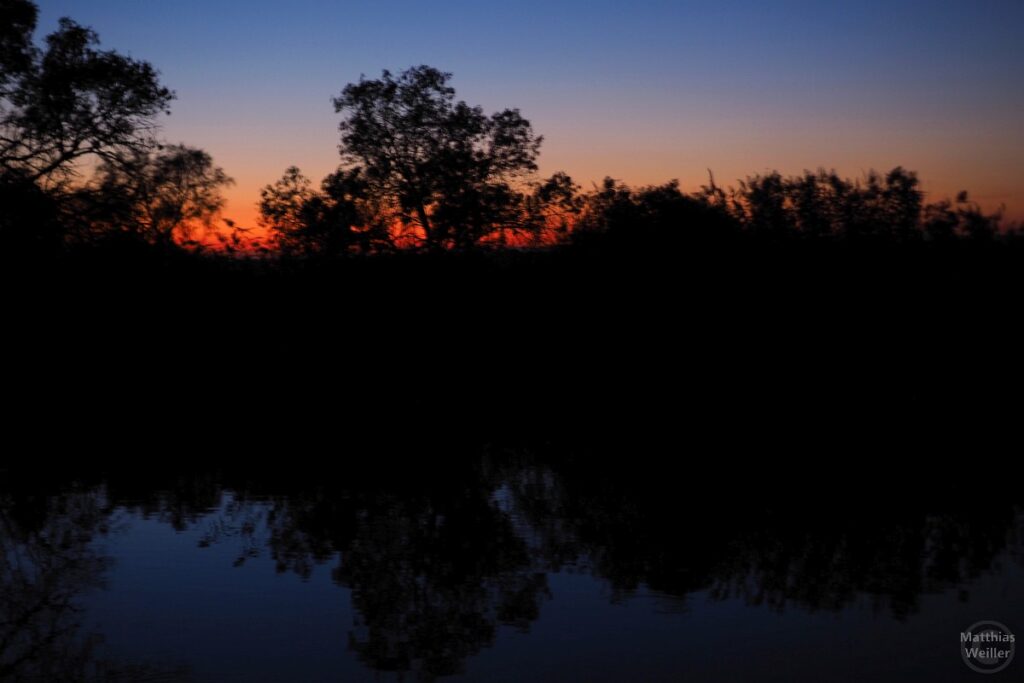 Sonnenuntergangsrot zur dunklen Blauen Stunde am Rhonekanal