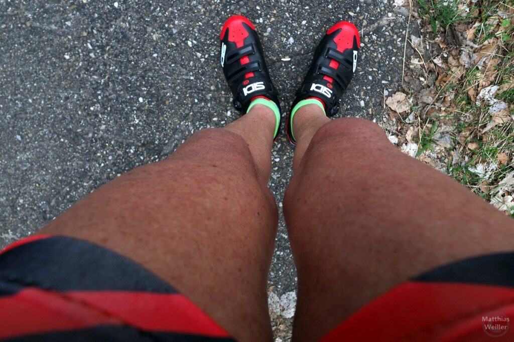 Neue Radschuhe Sidi rot/schwarz/weiß am Bein entlang von oben fotografiert