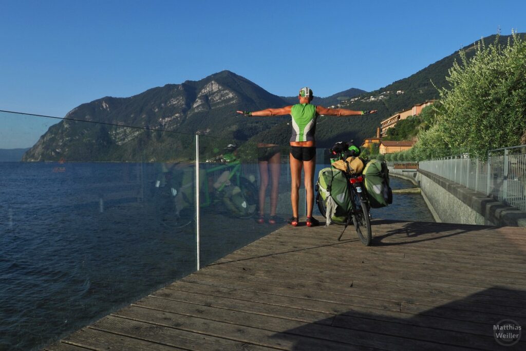 Podium über Iseosee mit Velo und Selbstporträt von hinten, Arme ausgebreitet