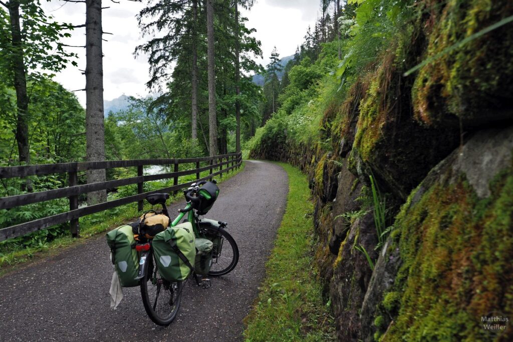 Velo auf Radweg zwischen Felsmauer und Bergfluss