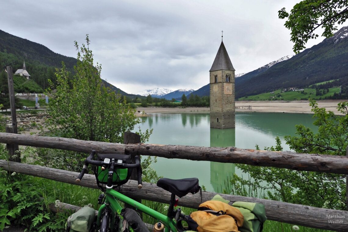 Kirchturm von Graun im Wasserbecken des im sonst ausgebaggerten Reschensee