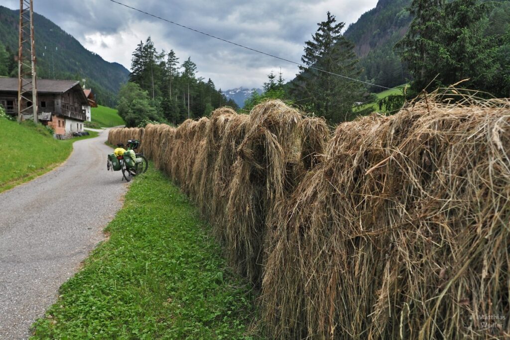 Aufgehängtes Heu an Bergstraße, mit Velo