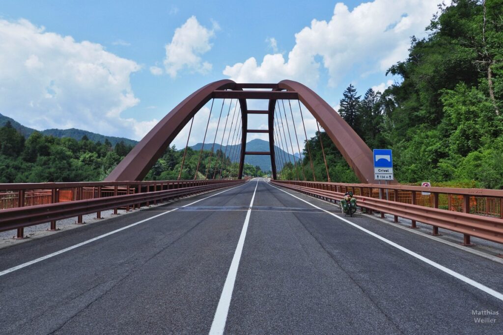 Stahlbogenbrücke in Frontperspektive, mit Velo