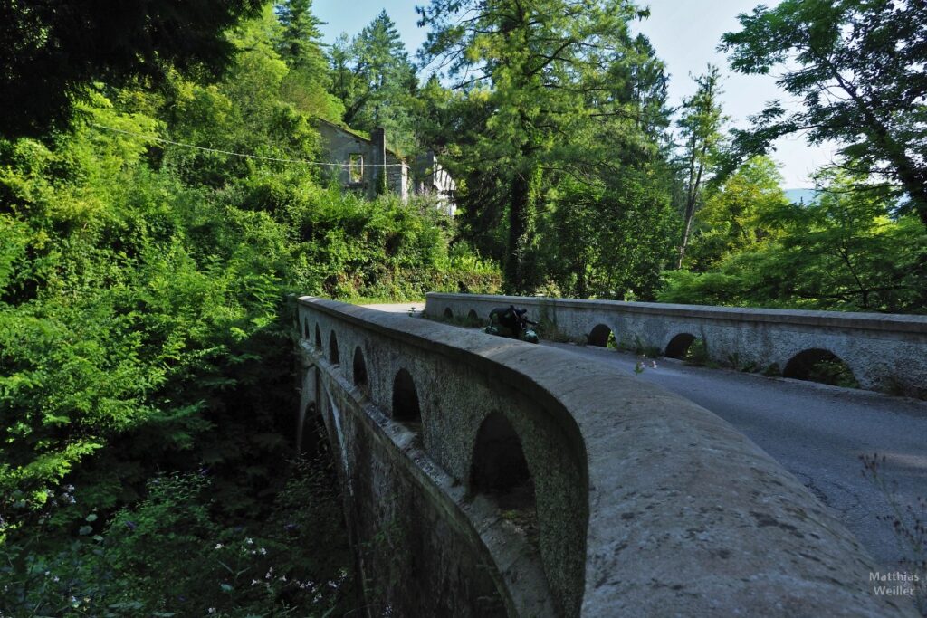 Brücke mit alter Leitmauer und Hausruine, mit Velo