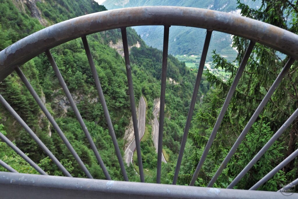 Blick nach unten auf Spitzkehre durch Metallgeländer