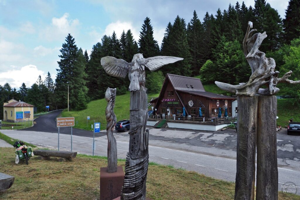 Holzskulpturen mit Chalet, Kapelle, Velo am Passo Sommo