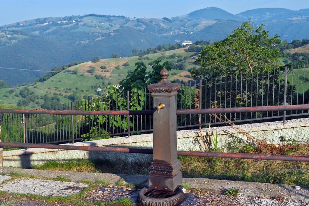 Trinkbrunnen mit Ausblick auf Tal und Hügelbergland in Sprea