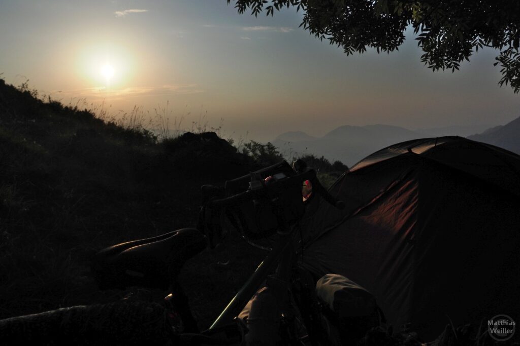 Sonnenaufgang mit Zelt und velo im Gegenlicht