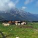 Kuhweide vor Bergkulisse, teils in Wolken am Passo di Campogrosso