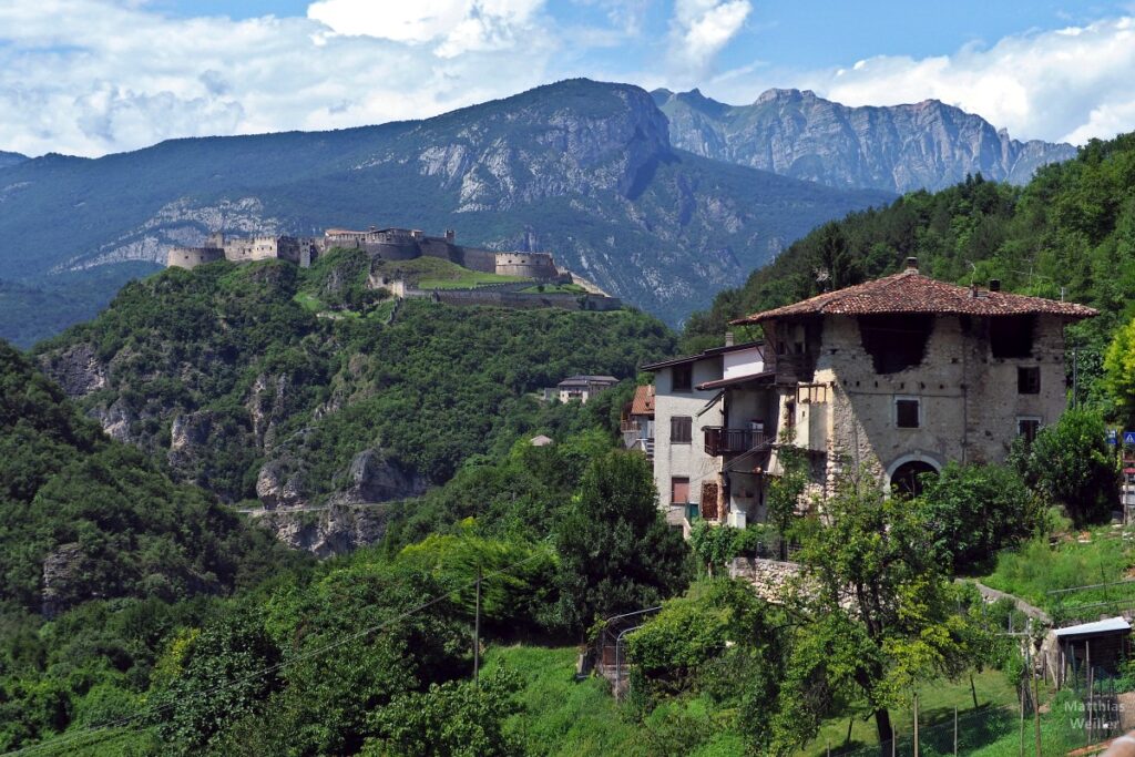 Bergkulisse mit Castello Beseno und Haus im Vordergrund