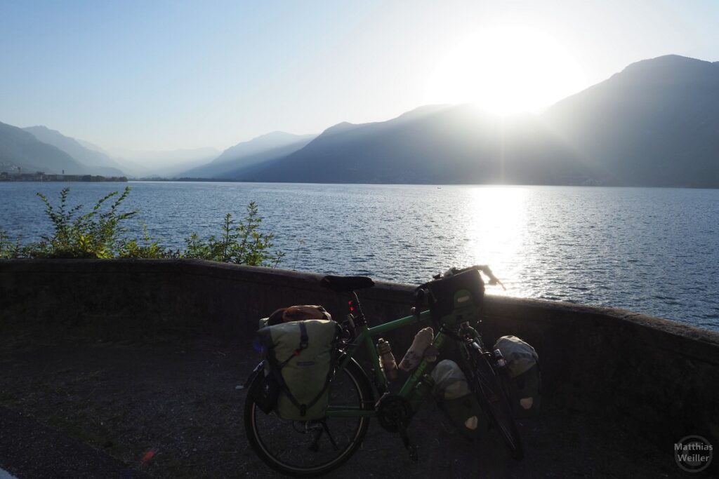 Seeblick im Gegenlicht der Morgensonne. mit Velo