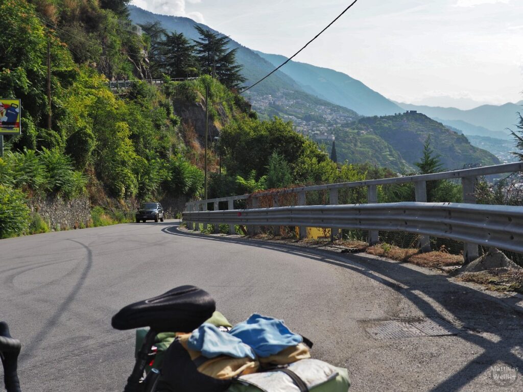 Straße mit Leitplanke, Auto, mit Velo oberhalb Sondrio