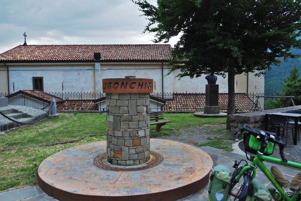 Steinrundel mit Ortsschild Ligonchio auf rundem Roststahl, mit Reisevelo