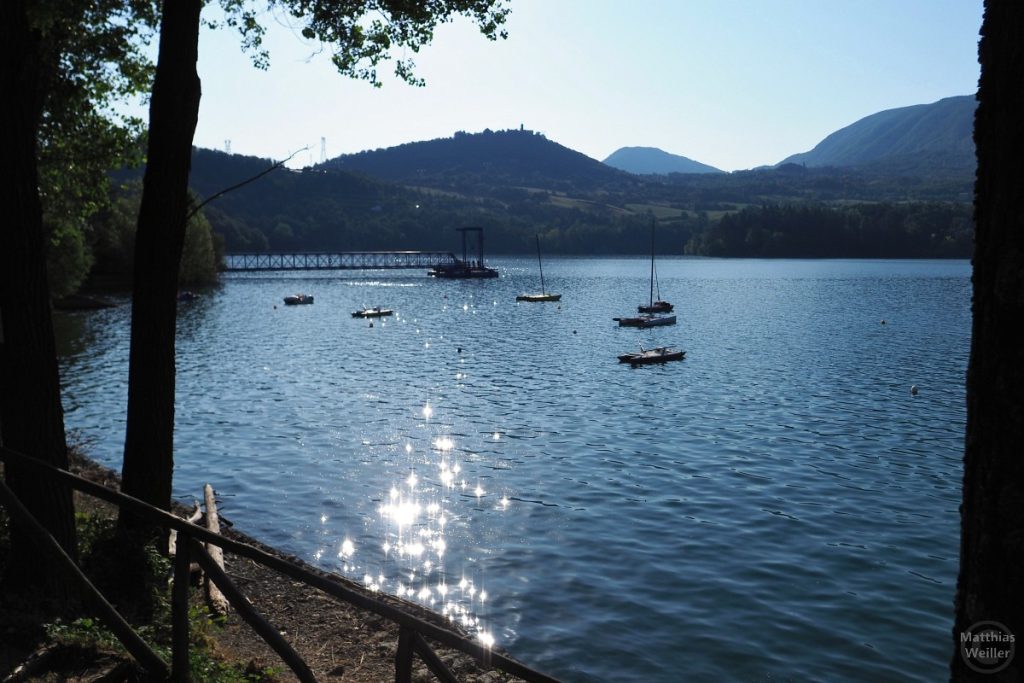 Gespiegelte Sonne im Lago di Suviana, mit Booten, Landungsbrücke